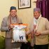 CM Pushkar Singh Dhami is giving a bag of Basmati rice of Ex CM Harish Rawat